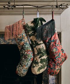 three christmas stockings hanging from a fireplace mantel