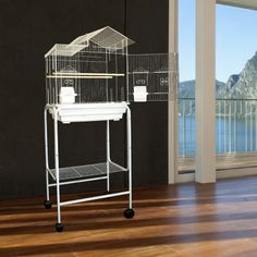 a white bird cage sitting on top of a wooden floor