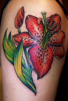 a colorful flower tattoo on the back of a woman's arm