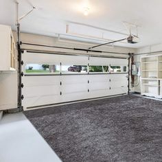 an empty garage with no one inside or outside the door and two open doors on either side