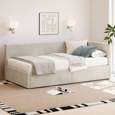 a bed sitting on top of a rug in a bedroom next to a wall mounted light