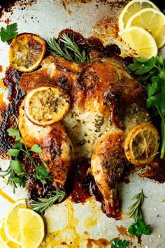 a roasted chicken with lemons and herbs