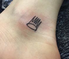 a foot with a crown tattoo on it