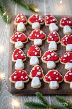 cookies decorated with red and white mushrooms on a wooden board