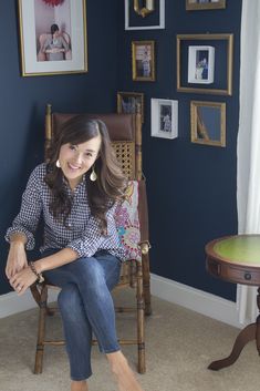 a woman sitting in a chair smiling at the camera