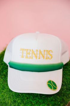 Ace your style game with our Tennis Ribbon White Trucker Hat! This playful hat features a gold Tennis patch and green ombre ribbon for a unique and stylish look. The green tennis ball patch on the bill adds a touch of humor to your outfit. Game, set, match! Sporty Snapback Baseball Cap For Tennis, Green Sporty Trucker Hat With Curved Brim, Sporty Green Trucker Hat With Curved Brim, White Baseball Cap For Tennis, White Tennis Baseball Cap, Sporty Green Snapback Trucker Hat, Sporty Snapback Hat For Tennis, White Adjustable Hat For Tennis, White Adjustable Tennis Hat