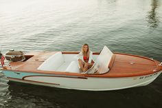 a woman sitting in a small boat on the water