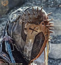 a close up of a person wearing a helmet with spikes on it