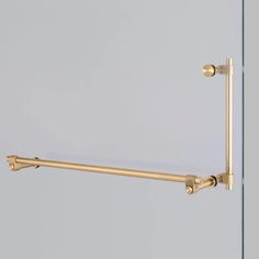 the brass towel bar is mounted on a glass wall