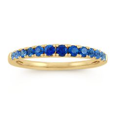 This gorgeous multi-colored blue ring features 13 pave-set round sapphires in varying shades of blue  at approximately .56 carat total gem weight. Crafted of quality 14k yellow gold  each gemstone has been hand-matched for consistent color. The ring measures 1.5mm wide and is the perfect birthstone gift for the month of September. Yellow Gold Stackable Sapphire Ring, 14k Gold Sapphire Half Eternity Ring, Multi-stone Sapphire Ring In Yellow Gold, Blue Sapphire Half Eternity Ring In 14k Gold, Gold Sapphire Half Eternity Ring, Yellow Gold Sapphire Stackable Rings With Gemstone, Yellow Gold Sapphire Ring With Round Band, Blue Multi-stone Sapphire Ring In 14k Gold, Fine Jewelry Sapphire Half Eternity Ring