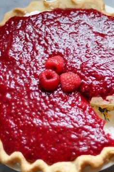 a pie with raspberry filling and two pieces taken out of it on a plate