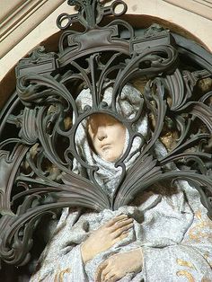 a statue is shown in front of an ornate design on the side of a building