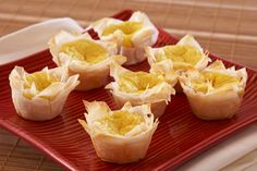 small cups filled with food sitting on top of a red plate