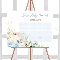 an easel with a baby's birth announcement on it and flowers in the background