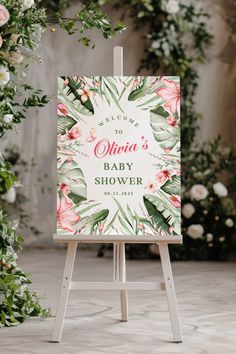 a sign with flowers and greenery on it that says welcome to the baby shower