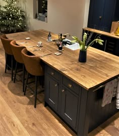 a kitchen island with chairs around it and a wine bottle on the counter top next to it