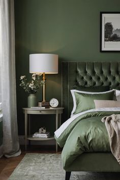 a bedroom with green walls and a white rug on the floor next to a bed