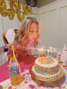 a woman blowing out candles on a birthday cake