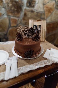 a chocolate cake sitting on top of a table next to white plates and silverware