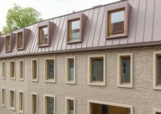 an apartment building with several windows on each side and a metal roof over the top