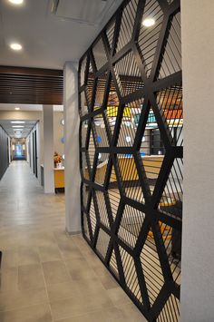 an office hallway with decorative partitions on the wall and tile flooring in front of it