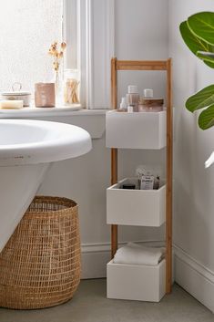 a white sink sitting next to a wooden shelf filled with containers and boxes on top of it