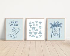 three framed art prints on a wooden floor in front of a white wall with blue accents