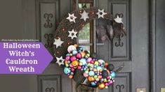 a wreath is hanging on the front door with balls and stars around it, as if for halloween