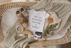 a baby's clothes and shoes are laying in a wicker basket