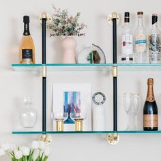 the shelves are filled with bottles, glasses, and other personalized items for guests to drink