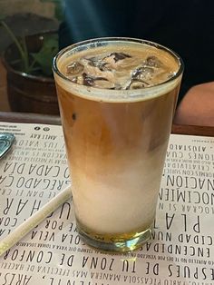 a drink sitting on top of a table next to a paper with writing on it