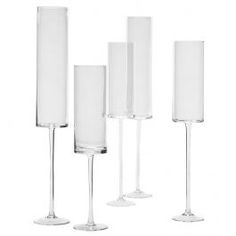 four wine glasses are lined up next to each other on a white background, with one empty glass in the middle