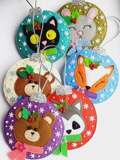 four christmas ornaments with animals and snowflakes on them