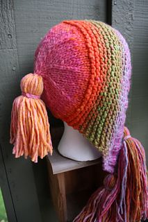 a knitted hat with tassels on top of a mannequin head