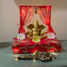 an elephant statue sitting on top of a table next to a candle and spoons