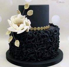 a black cake with white flowers on top