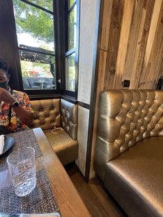 a person sitting at a table with a plate of food in front of them and a window