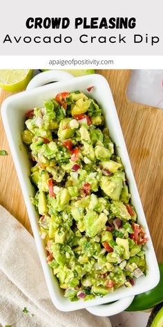 a white bowl filled with guacamole salad next to sliced limes