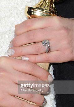 two hands with wedding rings on their fingers, one holding a gold purse and the other wearing