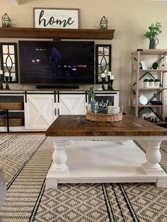 a living room with a large tv mounted on the wall and a coffee table in front of it