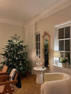 a living room filled with furniture and a christmas tree next to a window covered in lights