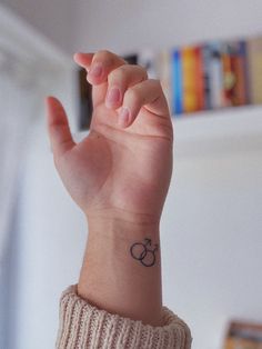 a person with a small tattoo on their wrist is holding up her hand in the air