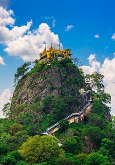 a castle on top of a mountain surrounded by trees