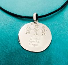 a silver pendant with two children engraved on it