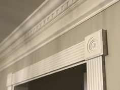 the corner of a room with a window and white molding on the trimming