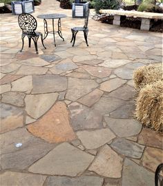 two chairs and a table sitting on top of a stone patio