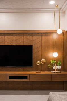 a large flat screen tv sitting on top of a wooden entertainment center in a living room