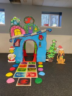 an indoor play area with toys in the shape of a house and children's pictures on the floor