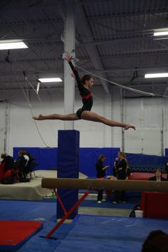 a person on a balance beam in a gym