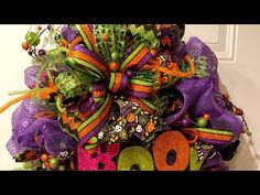 a purple and orange halloween wreath with the word boo on it's front door